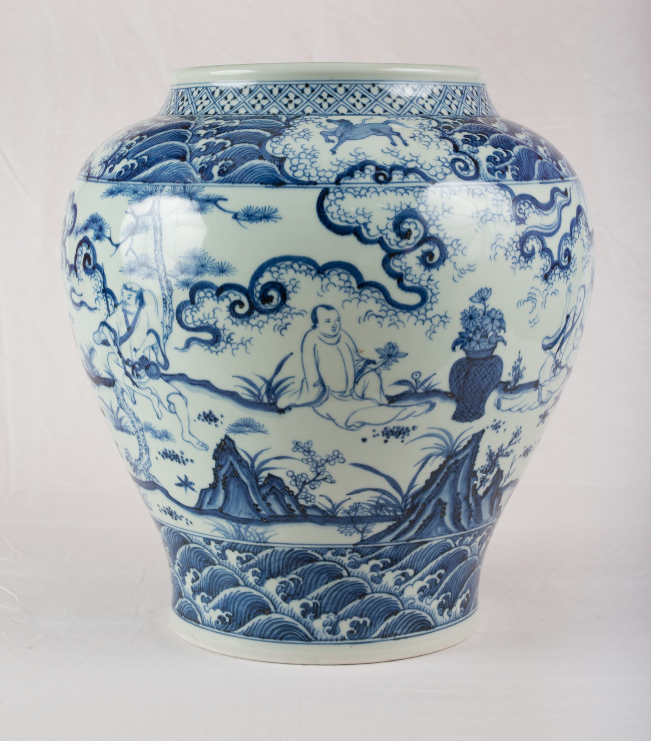 Blue and white porcelain vase with intricate cloud and wave patterns and a patterned neck area edge as seen in the image.